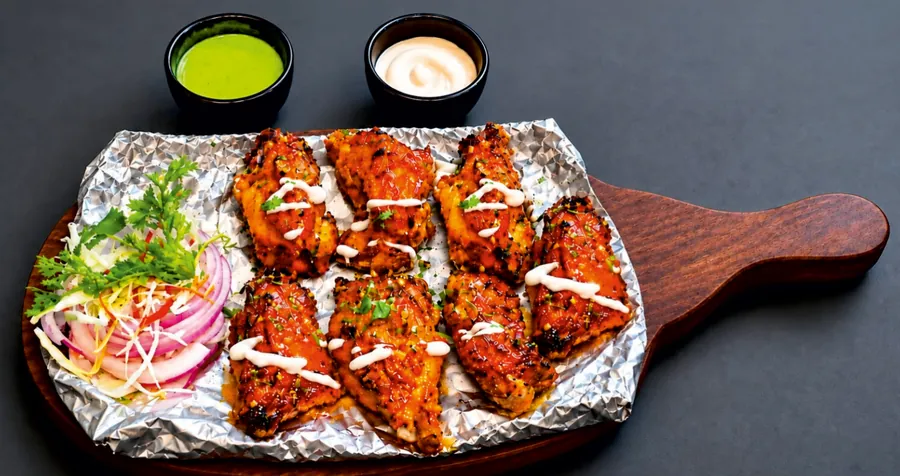 Pahadi kebab with bone on a foil-lined sizzler board